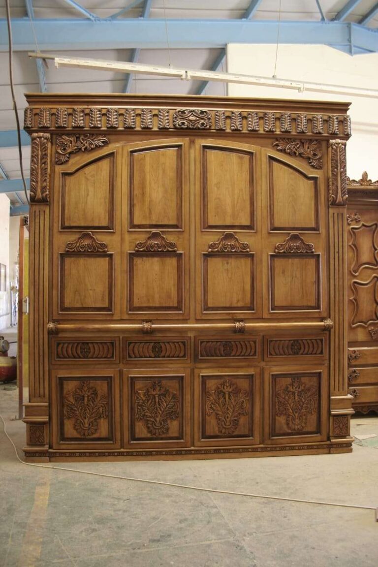 Large wooden cupboard with panelled doors, carved lower panels and a decorative cornice