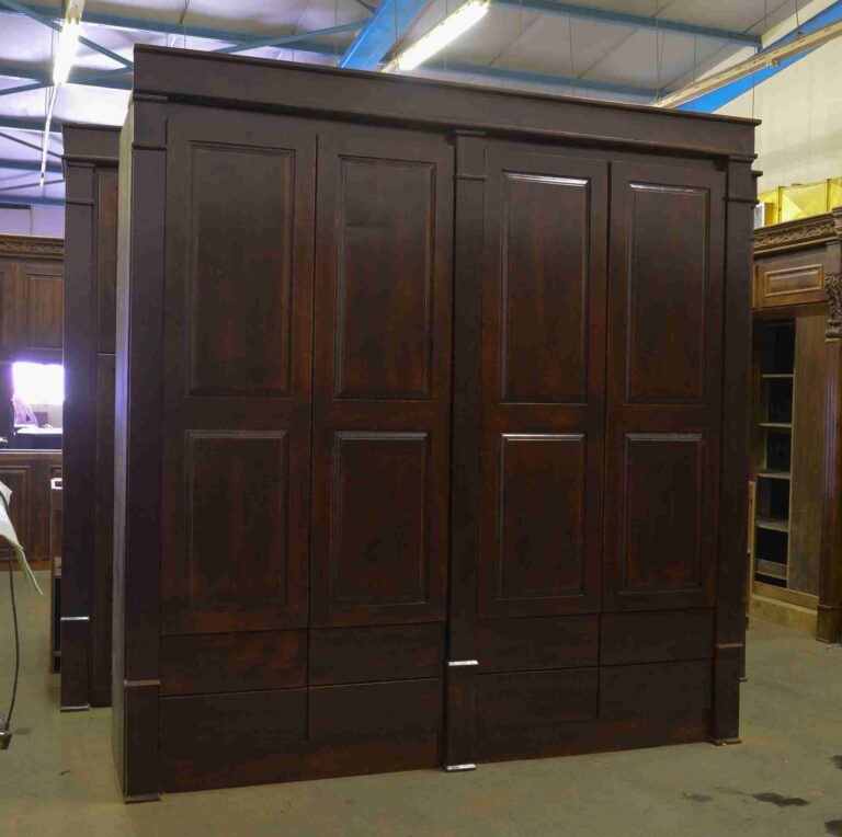 Dark wooden wardrobe with panelled doors and lower drawers