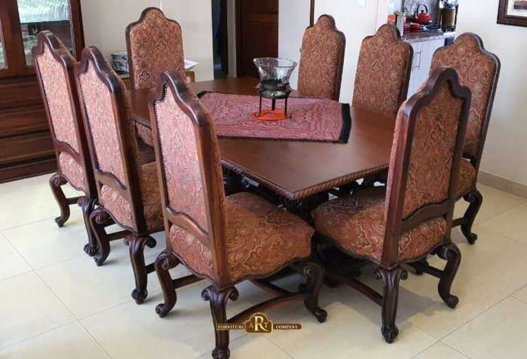 Wooden dining table surrounded by tall chairs with patterned upholstery and curved legs