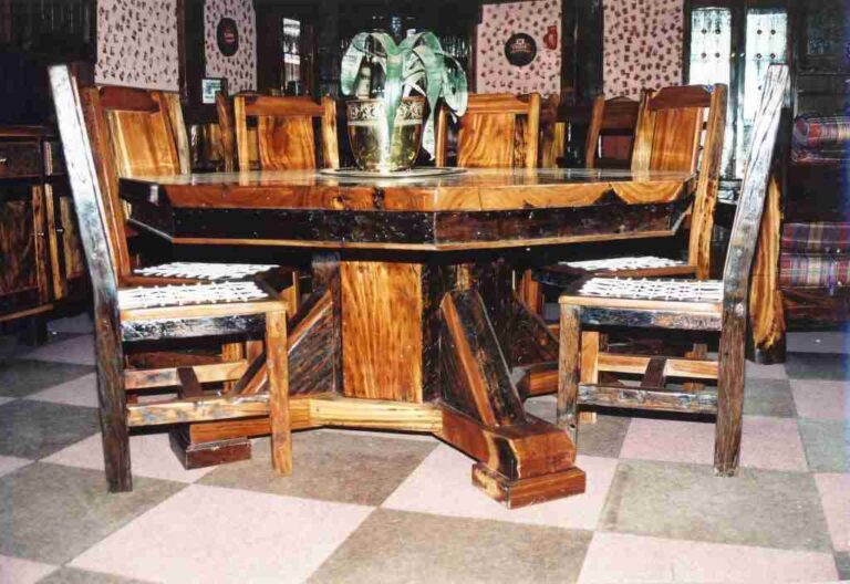 Wooden dining table with an angular pedestal base and matching straight-backed chairs