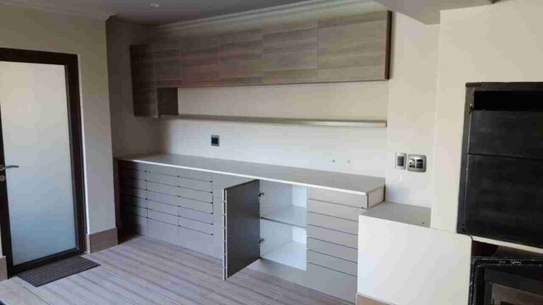 Grey kitchen wall and base cabinets with open storage compartments