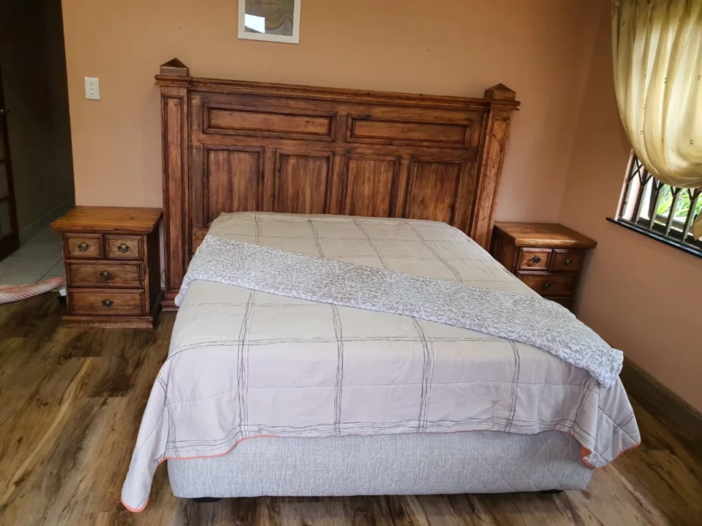 Panelled wooden headboard with matching bedside drawer units in a bedroom
