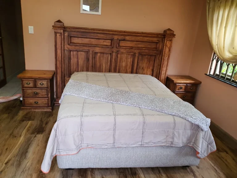 Panelled wooden headboard with matching bedside drawer units in a bedroom