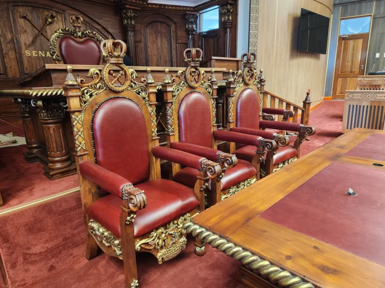 Three carved chairs with red upholstery and gold-coloured details for the Senate of Lesotho