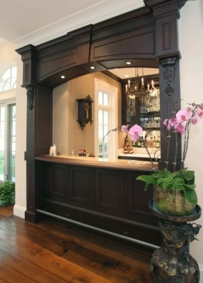 Dark panelled serving counter framed by carved columns and an overhead beam