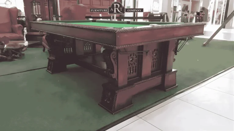 Carved wooden pool table with green cloth, panelled supports and decorative brackets
