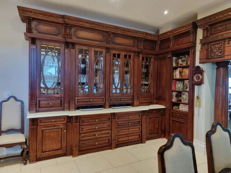Carved fitted display cabinets with glazed doors, drawers and lower cupboards