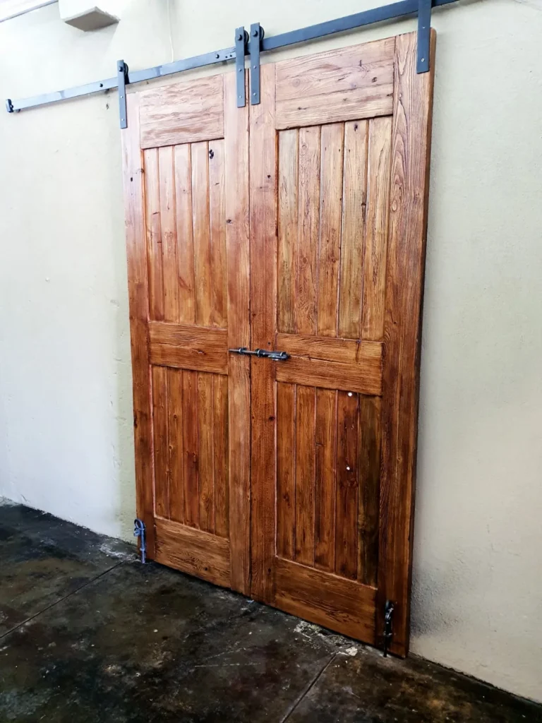 Pair of panelled timber sliding doors on exposed overhead hardware