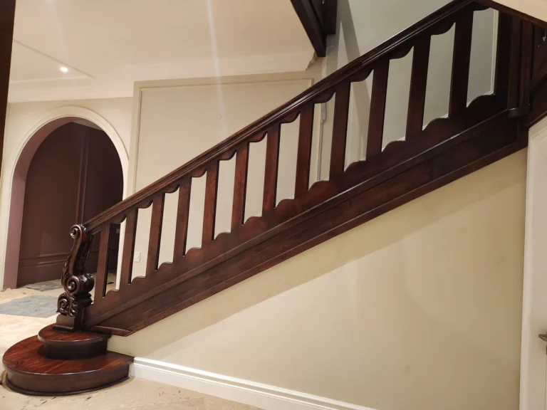 Wooden staircase with a shaped balustrade and carved newel post